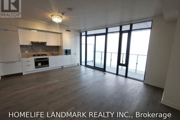 View of the open concept living area and kitchen with white cabinets and appliances. - 4201 - 20 Lombard Street, Toronto