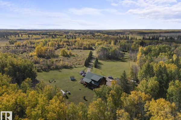 Aerial view of the log cabin and its property surrounded by vast autumn forests and fields. - 42030 Twp Rd 604, Rural Bonnyville M D 