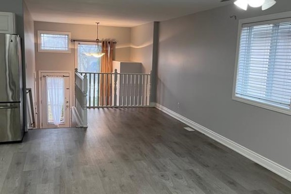 Open concept living area with a view of the backyard and staircase. - 4207 Whiskey Avenue, Windsor