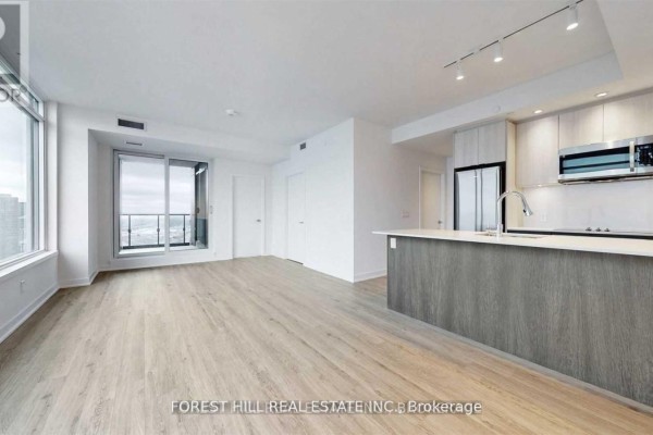 Open concept living area with light wood floors, white walls, and a kitchen island. - 4208 - 1928 Lake Shore Boulevard W, Toronto