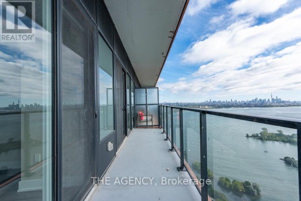 Balcony with glass railing offering a view of the Toronto skyline and lake. - 4208 - 20 Shore Breeze Drive, Toronto