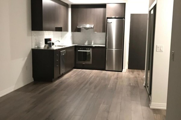Corner kitchen with dark wood cabinets, stainless steel appliances, and dark wood floors. - 421 - 50 Ann O'reilly Road, Toronto
