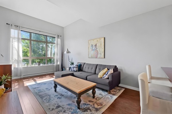 Cozy living area featuring artwork, sofa, and large window - 421 15918 26 Avenue, Surrey