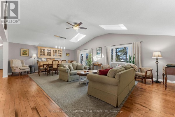 Open concept living/dining with hardwood floors, vaulted ceiling, skylights, and French doors - 42125 Combermere Road Ne, Madawaska Valley