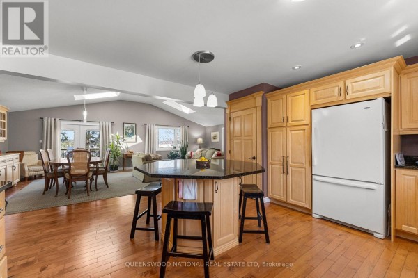 Open concept kitchen with granite island, hardwood floors, vaulted ceiling - 42125 Combermere Road Ne, Madawaska Valley