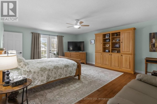 Bedroom with hardwood floors, French doors, ceiling fan, and built-in cabinet - 42125 Combermere Road Ne, Madawaska Valley
