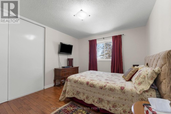 Bedroom with hardwood floors, sliding closet doors, wall-mounted TV - 42125 Combermere Road Ne, Madawaska Valley