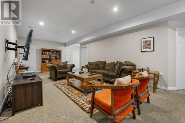 Finished basement living room with mounted TV, sofa, and recessed lighting - 42125 Combermere Road Ne, Madawaska Valley