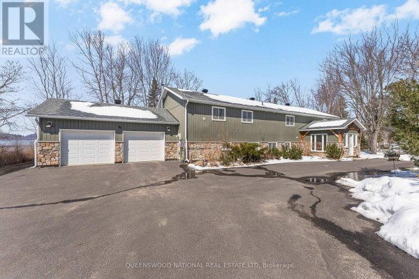 Exterior of house with two-car garage, stone facade, asphalt driveway, waterfront - 42125 Combermere Road Ne, Madawaska Valley