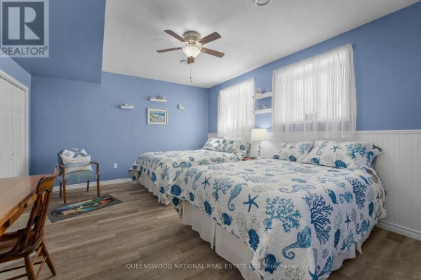 Bedroom with two beds, ceiling fan, wainscoting - 42125 Combermere Road Ne, Madawaska Valley