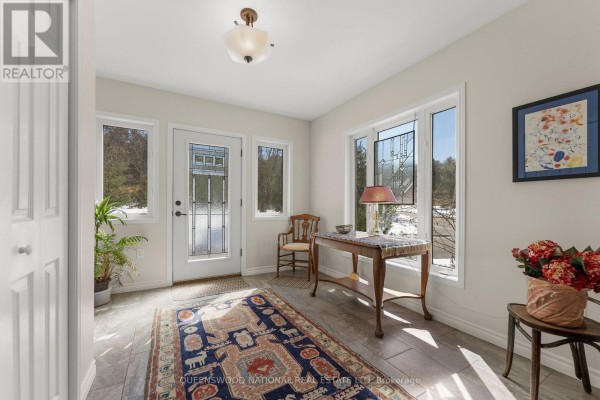 Entryway with decorative glass door, tile floors, and large windows - 42125 Combermere Road Ne, Madawaska Valley