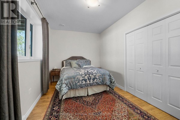 Bedroom with window, bi-fold closet doors, and hardwood floors - 42125 Combermere Road Ne, Madawaska Valley