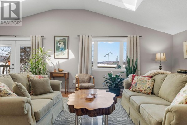 Living room with vaulted ceiling, skylight, and French doors - 42125 Combermere Road Ne, Madawaska Valley