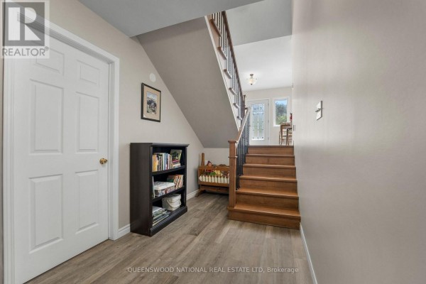 Hallway with wood stairs, wood-look flooring, interior door, and exterior door - 42125 Combermere Road Ne, Madawaska Valley