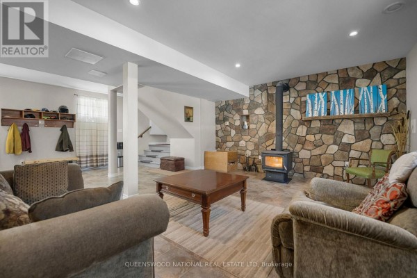 Finished basement with stone wall, wood-burning stove, tiled floors - 42125 Combermere Road Ne, Madawaska Valley