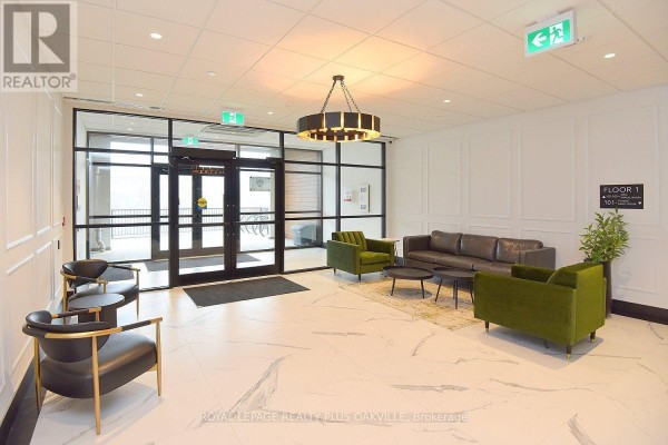 Apartment building lobby with marble tile floor, glass double doors, green velvet chairs, and sofa. - 422 - 1936 Rymal Road E, Hamilton