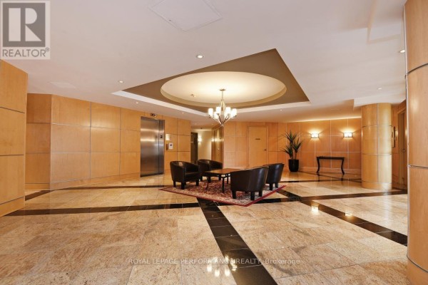 Lobby seating area with elevator, wood paneling, and marble flooring. - 422 - 205 Bolton Street, Ottawa