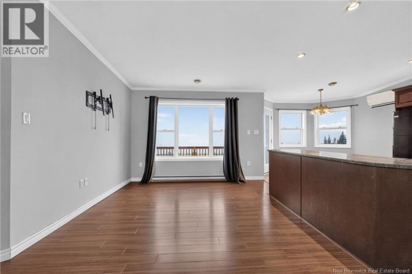 Living room with large windows showing a scenic view, dark wood floors, and a kitchen island. - 422 Indian Mountain Road, Stilesville