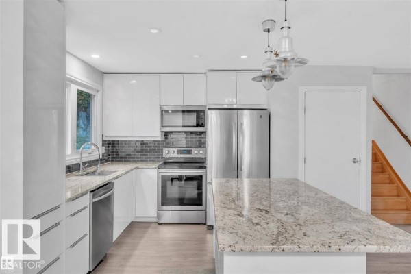 Modern kitchen with white cabinetry, granite countertops, stainless steel appliances, and a tiled backsplash. - 42204b Twp Rd 624, Rural Bonnyville M D 