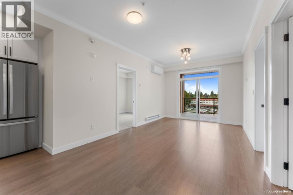 Empty bedroom with grey carpet, large window with natural light, and beige walls. - 423 12109 223 Street, Maple Ridge