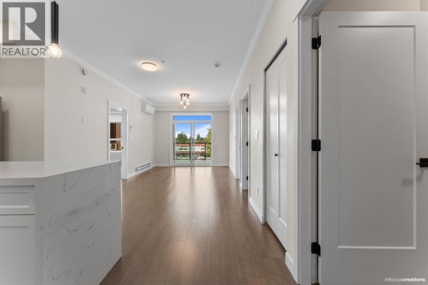 Bathroom with white vanity, toilet, white tiled shower/tub surround, and modern light fixture. - 423 12109 223 Street, Maple Ridge