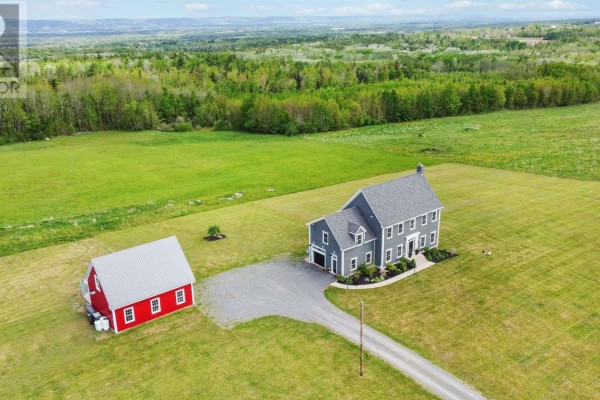 Aerial view of a grey house and a red barn situated on expansive green fields under a cloudy sky. - 423 Canaan Road, Nicholsville