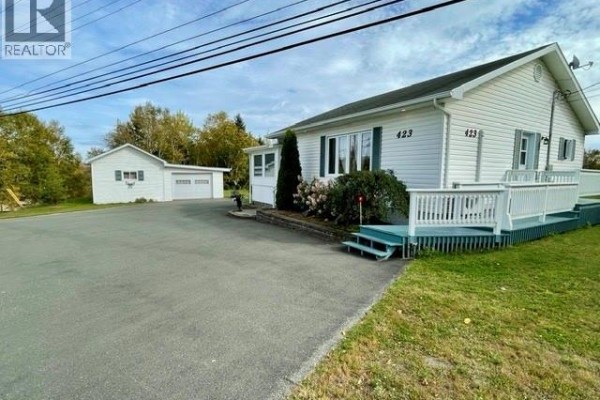 White bungalow with a detached two-car garage and a deck on the right. - 423 Darlington, Dalhousie