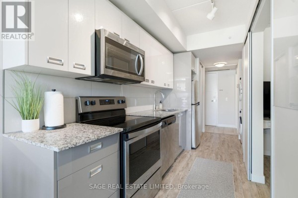 Kitchen with white and grey cabinets, granite countertops, stainless steel appliances, and a potted plant. - 424 - 257 Hemlock Street, Waterloo
