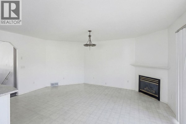 Empty living room with fireplace and circular layout - 424 Mclennan Mclennan Crescent, Kelowna