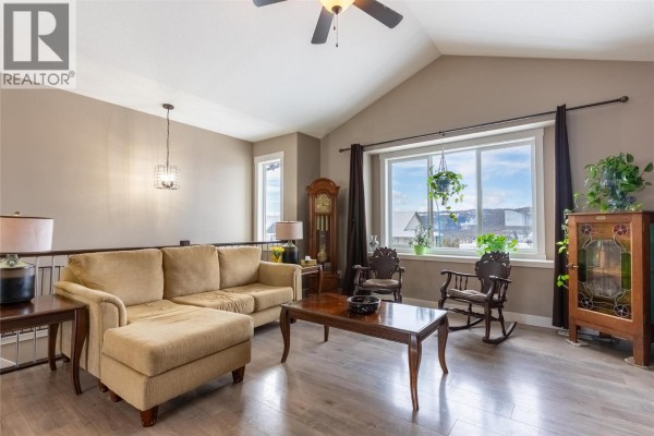 Bright living room corner with a view, featuring a rocking chair and decorative plants. - 425 Aralia Place, Logan Lake