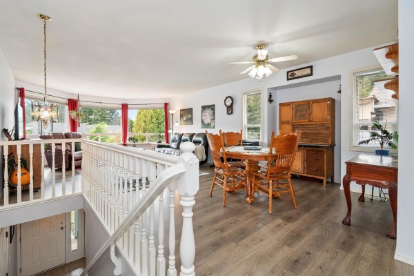 Open concept living and dining area with wood floors, a dining set, and a view of trees. - 425 Hadway Drive, Harrison Hot Springs, Harrison Hot Springs