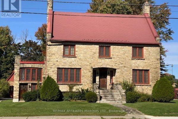Facade of a two-story stone house with a red roof and entrance steps. - 425 Second St. E Street E, Cornwall
