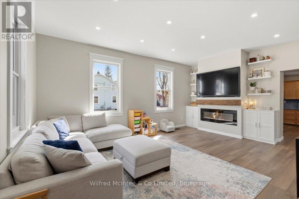 Modern living room with fireplace, built-in shelves, hardwood floors - 425 Yonge Street S, Brockton