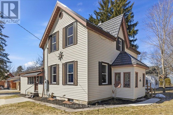 Two-story house with siding, shutters, metal roof, bay window - 425 Yonge Street S, Brockton