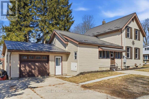 Front exterior of house with attached garage, metal roof, and vinyl siding - 425 Yonge Street S, Brockton