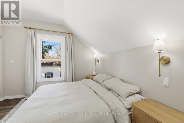 Renovated bedroom with sloped ceiling, window, and wall sconces - 425 Yonge Street S, Brockton