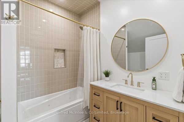 Modern bathroom with bathtub, tiled shower niche, and wooden vanity - 425 Yonge Street S, Brockton