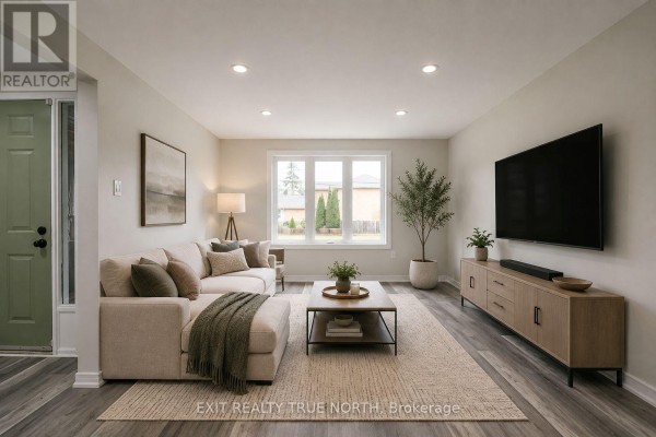 Living room with a sectional sofa, coffee table, and television on a media stand. - 426 Sunnidale Road, Barrie