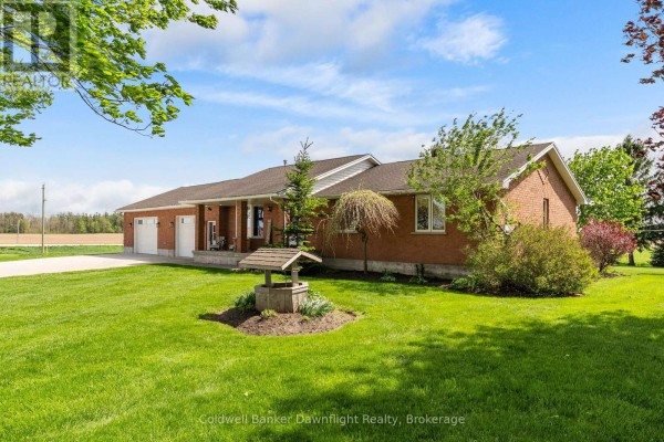 A single-story brick home with a well and mature trees in the front yard. - 42633 Moncrieff Road, Morris Turnberry