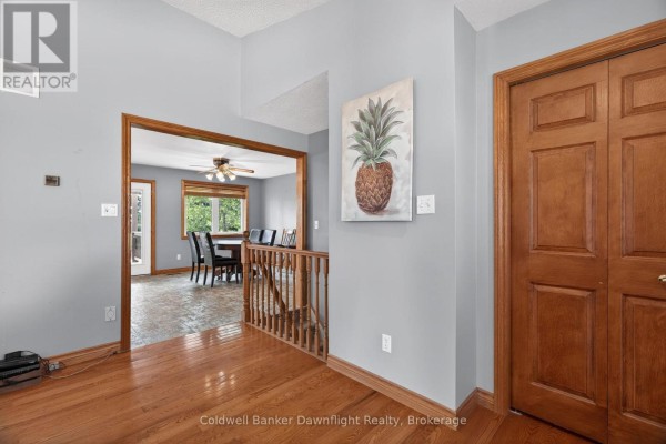 Interior entryway looking towards a dining room with a wooden staircase and hardwood floors. - 42633 Moncrieff Road, Morris Turnberry