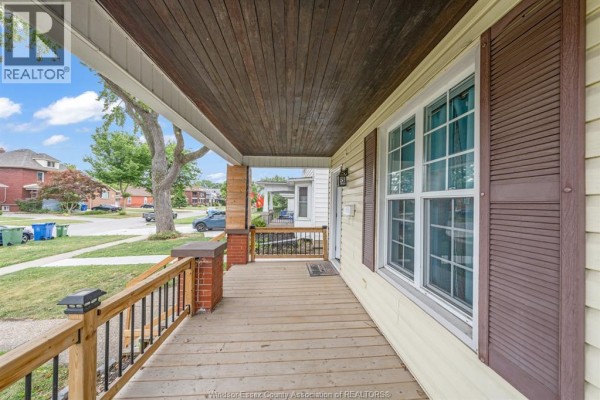 Side view of a light yellow duplex with dark brown shutters and a grass lawn. - 427 Cameron, Windsor