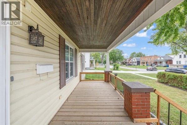 Interior dining or living area with a wooden bar, wood paneling, and laminate floors. - 427 Cameron, Windsor
