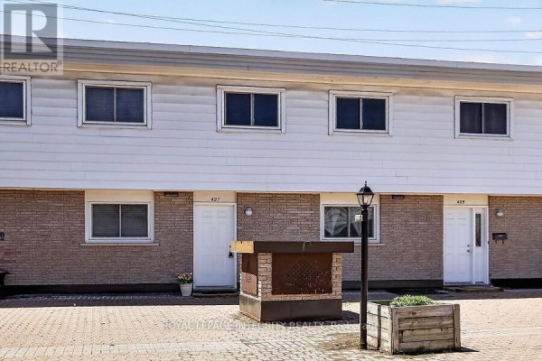 Front view of townhouse with snow-covered planter and entry doors - 427 Moodie Drive, Ottawa