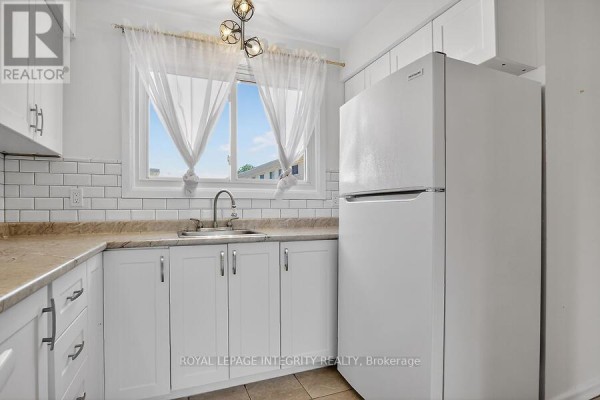 View from kitchen to living area with natural light and access to outdoor space - 427 Moodie Drive, Ottawa