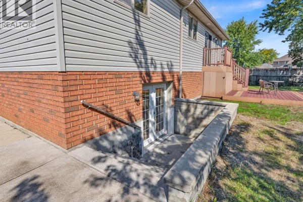 Walkout basement entrance with double doors leading from a concrete patio to the backyard. - 4274 Dennison Court, Windsor
