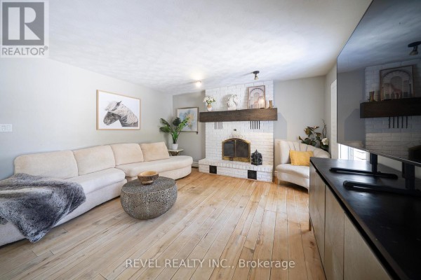 Close-up of white brick fireplace with large wooden mantle and arched firebox. - 428 Charlotteville Road 1, Norfolk