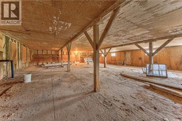 Long interior view of a large unfinished commercial space with wooden support beams. - 428 Lynden Road Unit# Building 4, Upper #1 & #2, Brantford