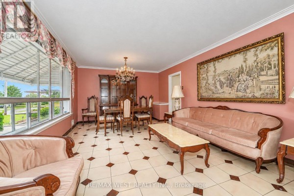 Living room with pink walls, chandelier, and dining area with a large window - 428 Maple Leaf Drive, Toronto