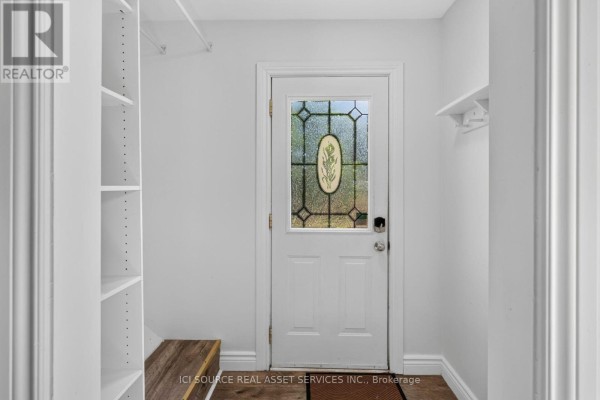 Open-concept living area with a white kitchen, island, and stairs. - 4284 Fly Road, Lincoln