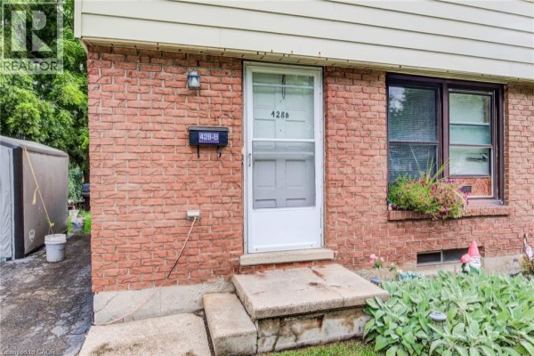 Close-up of the front door entrance with address 428B, brick exterior, and concrete steps. - 428b Dunvegan Drive, Waterloo